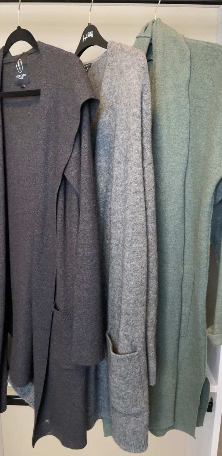 three long sweater jackets in various colors